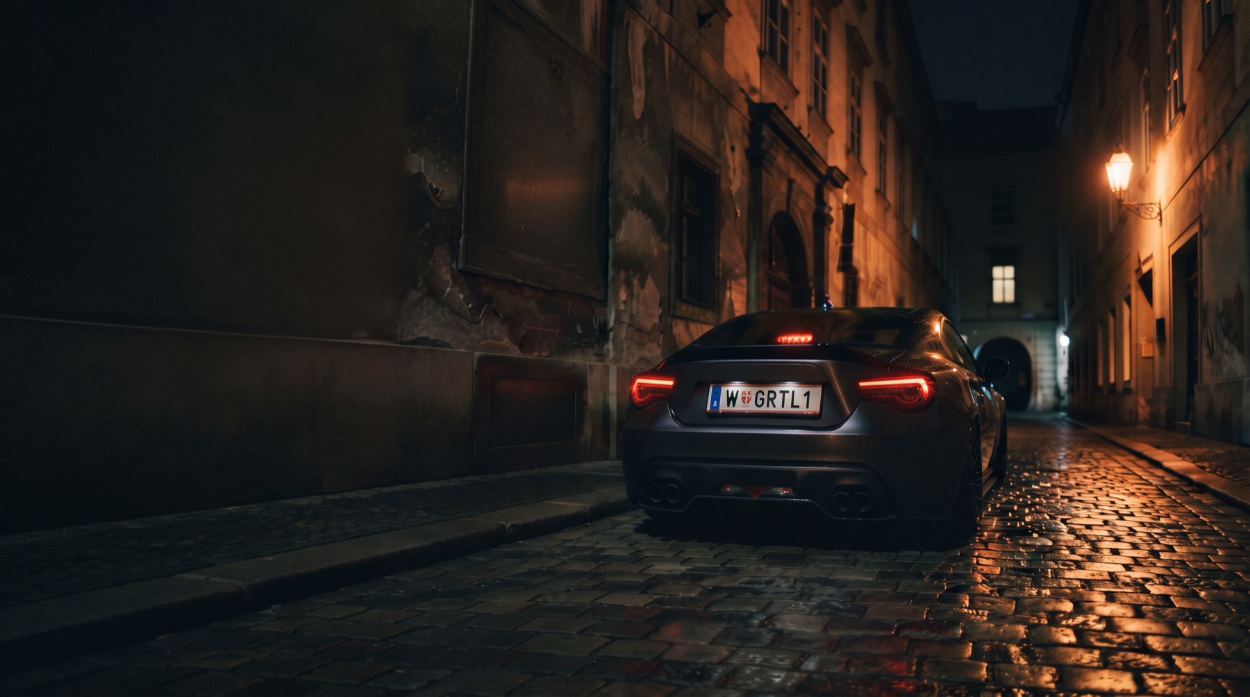 Eine Gasse in Wien bei Nacht: Im Licht einer Laterne steht ein dunkles Auto mit dem Kennzeichen W GRTL1.